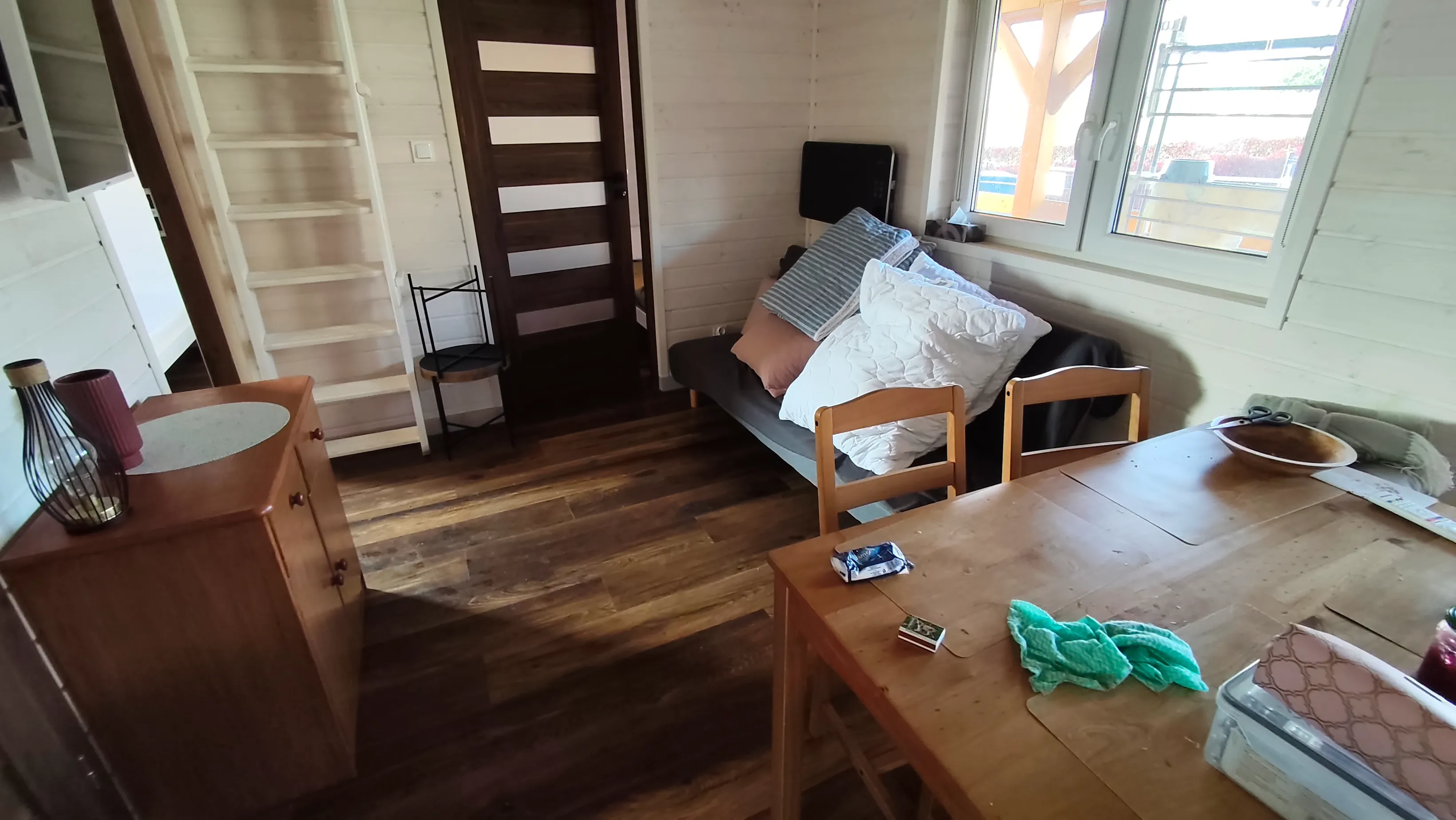 Salon domku Mat z sofą, stołem i oknem na taras